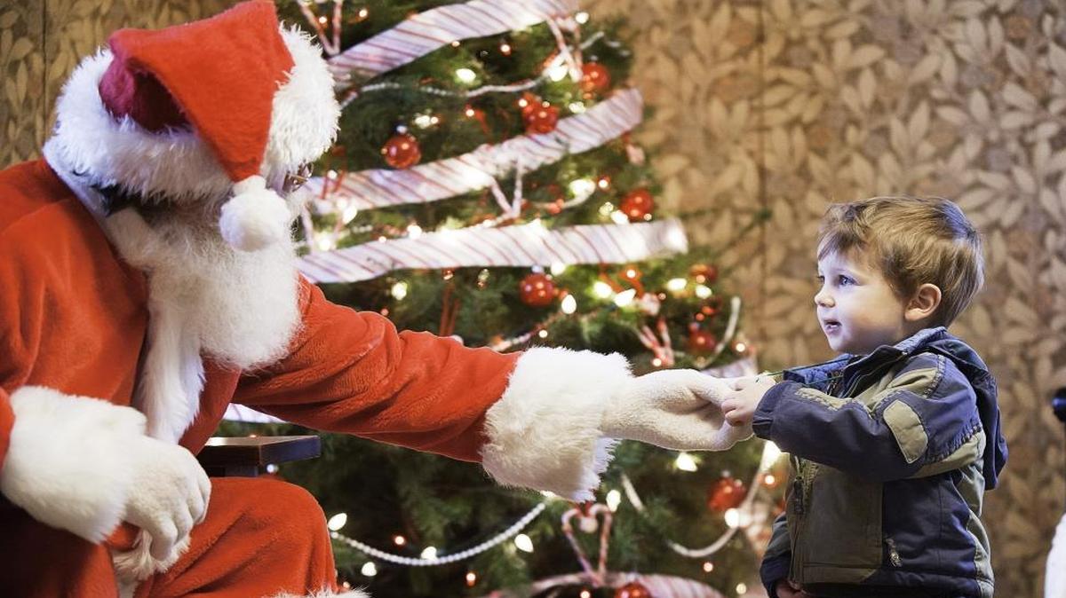 Santa gives Caleb Zelano Palmer, then 2, of Bellingham, a stocking with candy canes at the Shields House during the Olde Fashioned Christmas in Pioneer Park in Ferndale. The 2015 event runs Friday through Sunday, Dec. 4-6.