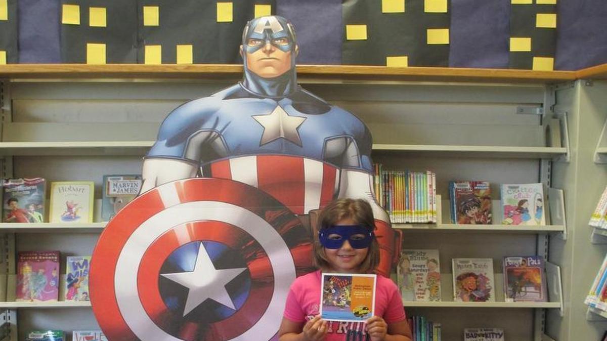 
Ruby Chesson, 7, stands in front of a Captain America cutout at Bellingham Public Library. The cutout will be available for pictures during the library’s Superhero Party on Friday, July 17.
