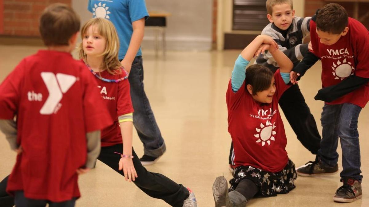 Children stretch during the YMCA’s spring break camp at Roosevelt Elementary School in 2013.