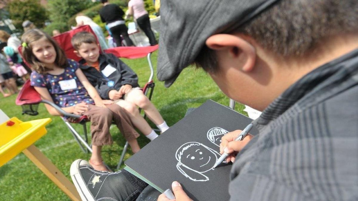 
Max Oviedo draws a caricature of Aviva, left, and Elisha Foster during the annual Children’s Craft Fair in 2012. This year’s fair will be Friday, July 31.
