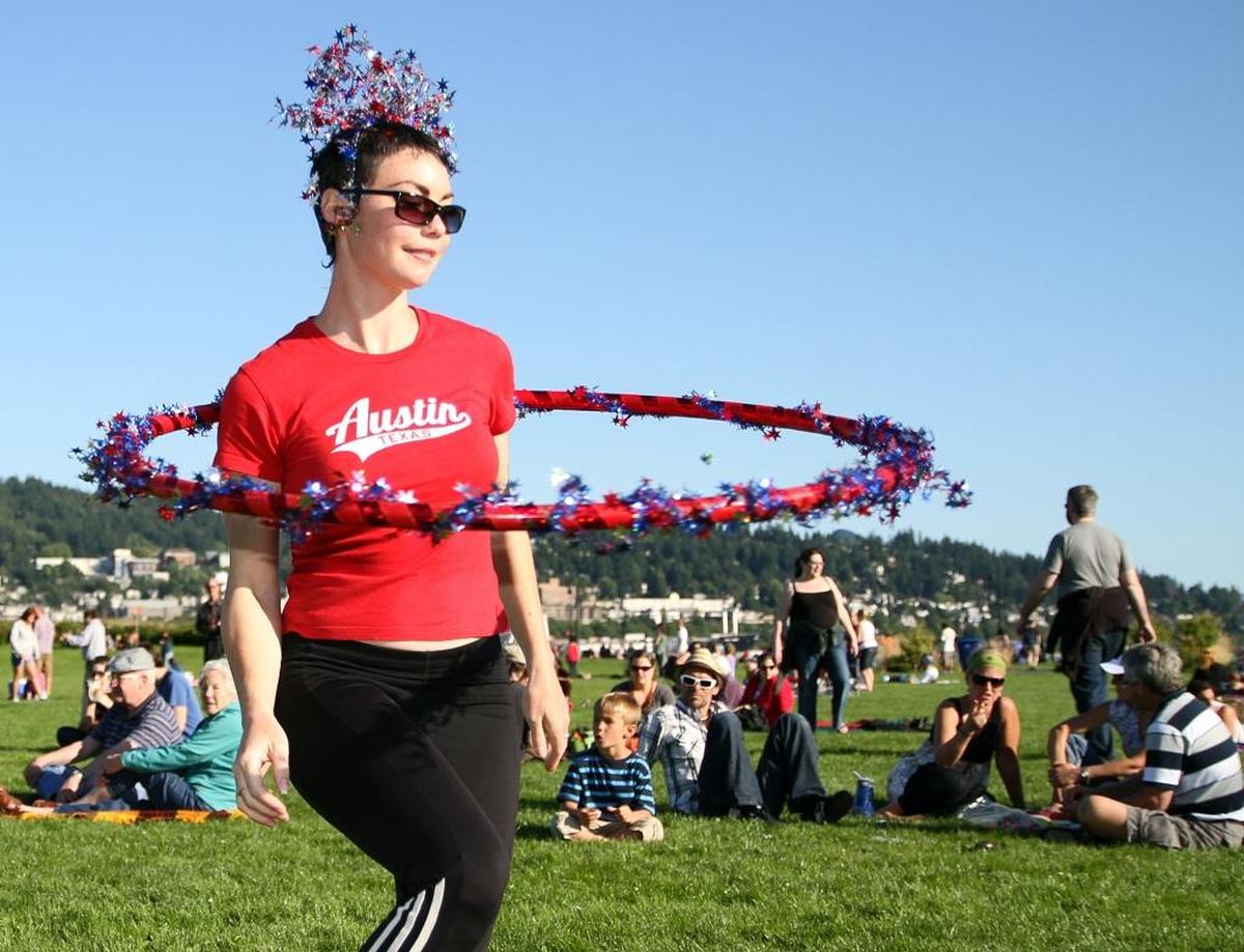 Jaime Berg, as known by her stage name Ms. B Hooping Allure, performs a hula hoop dance at Zuanich Point Park on July 4, 2012.
