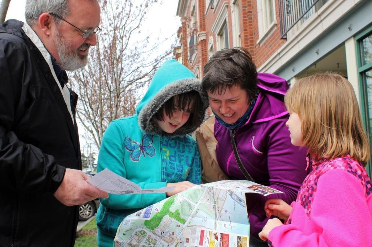 Visitors from Seattle examine a map of Fairhaven while participating in the scavenger hunt in 2014.