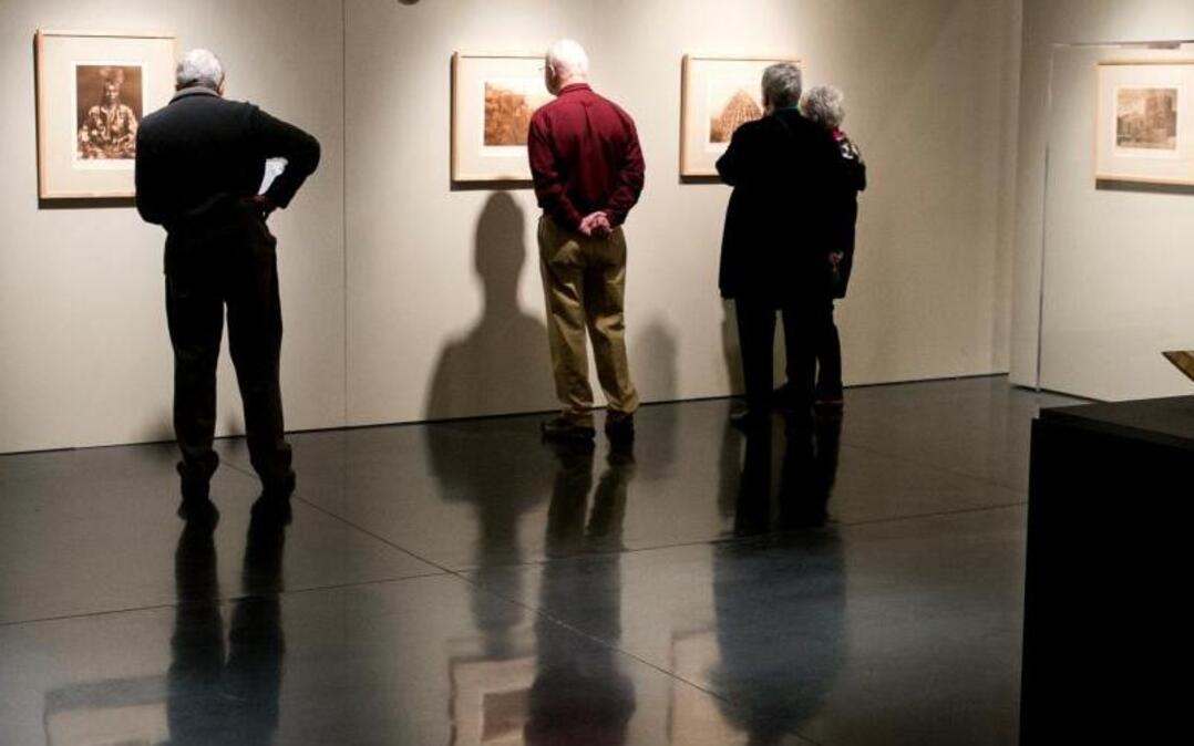 Visitors examine the Edward S. Curtis exhibit at Whatcom Museum’s Lightcatcher Building during a tour led by the museum’s docents.
