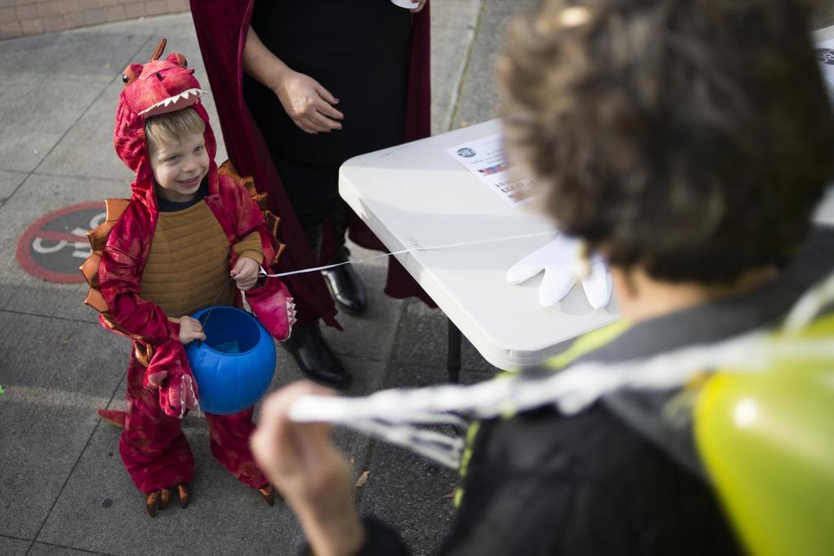 Matthew Einan, dressed as a dragon, waits for candy after playing games put on by First Baptist Bellingham during the annual Downtown Trick-Or-Treat in Bellingham last year.