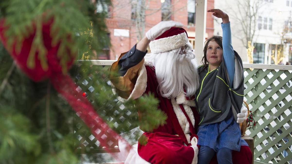 Scarlet Luft, right, describes the “big giraffe” she wants for Christmas to Santa Claus during Fairhaven Winterfest on Friday, Nov. 24, at the gazebo on the corner of 10th Street and Harris Avenue in Bellingham.
