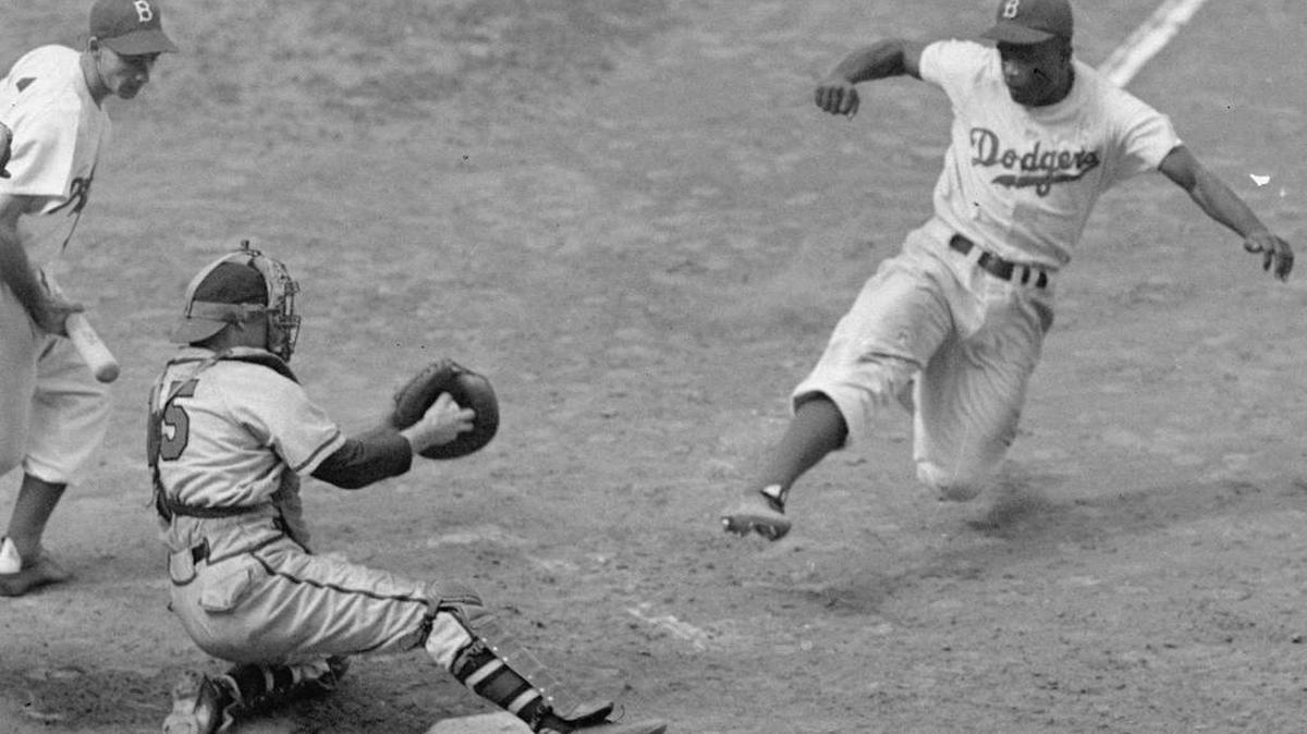 This Aug. 22, 1948, file photo shows Brooklyn Dodgers Jackie Robinson, right, stealing home plate against the Boston Braves.