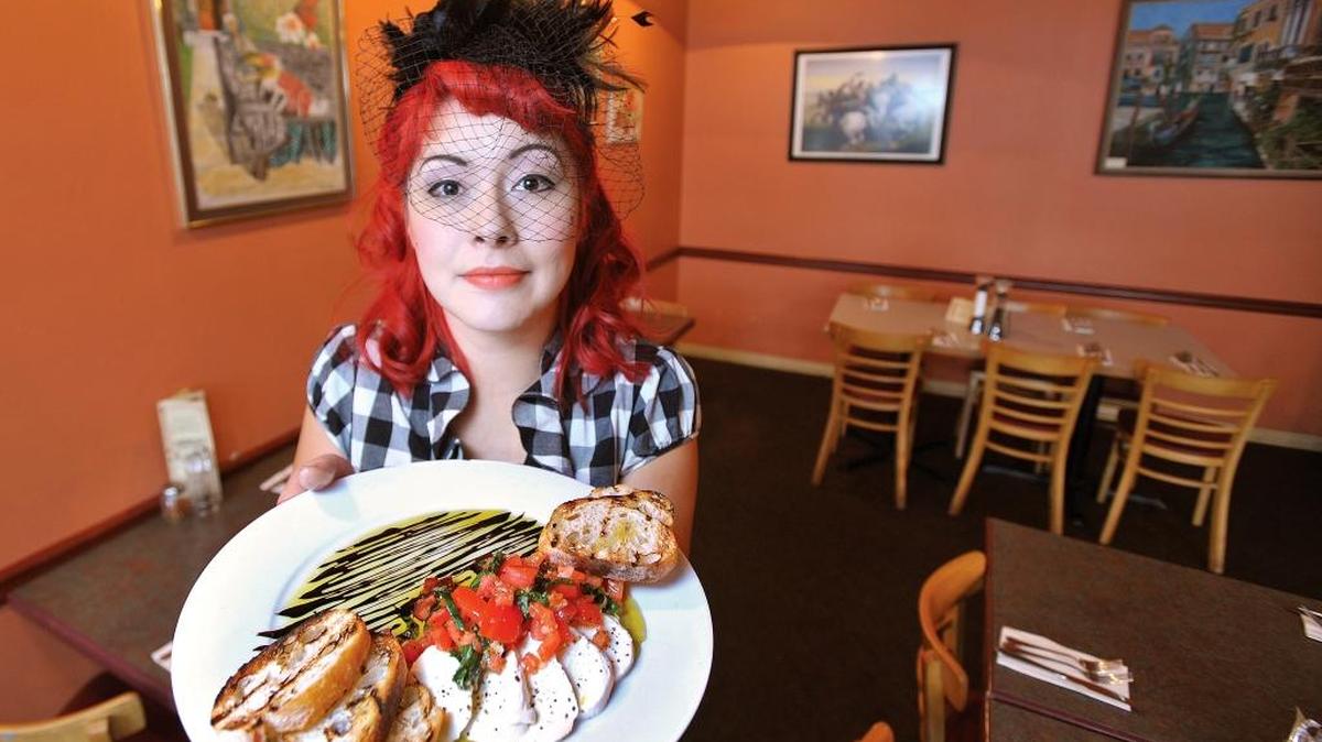 Waitress Giselle Neumann holds a plate of bruschetta at D’Anna’s Cafe Italiano in 2011, when the restaurant won a Readers’ Choice award from The Bellingham Herald.