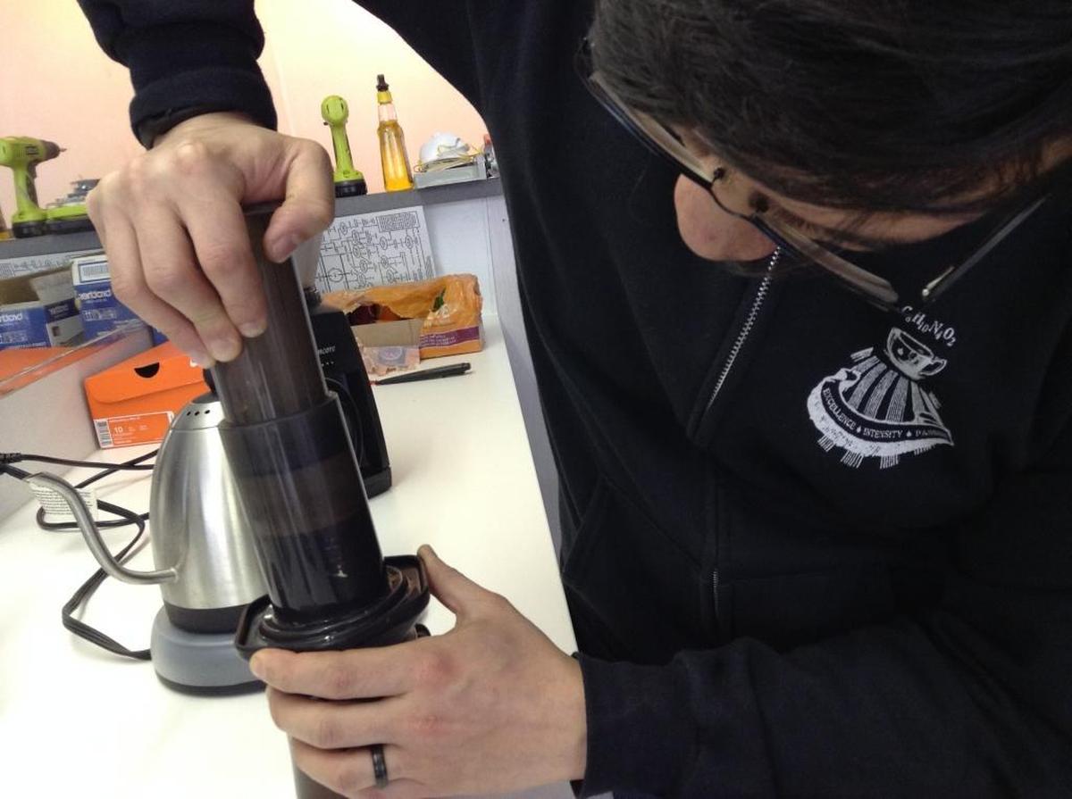Ryan Sui, co-owner of The Black Drop coffeehouse in Bellingham, works the plunger on his AeroPress during a demonstration.