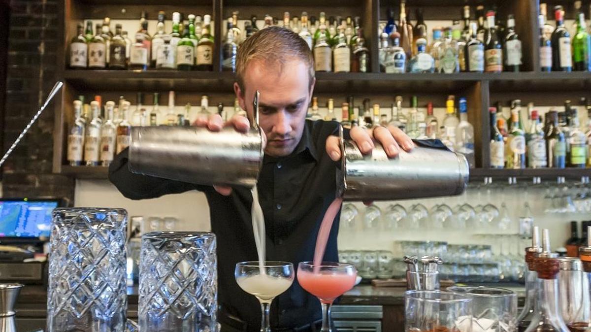 Dennis Schafer, bar and front of house manager, mixes drinks for guests at Rock and Rye Oyster House on State Street in the Herald Building on Sept. 29, 2015, in Bellingham.