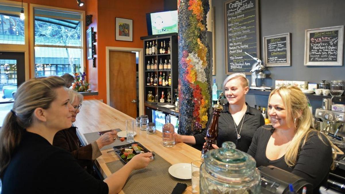 Customers Khara Turner, left, and Alana Hansen are served by Lydia Davis and Brie Mueller at the new Eat Restaurant and Bar in downtown Bellingham on Friday, Feb. 5, 2016. Co-owner Eric Truglas calls the food “American farm with a touch of French.”