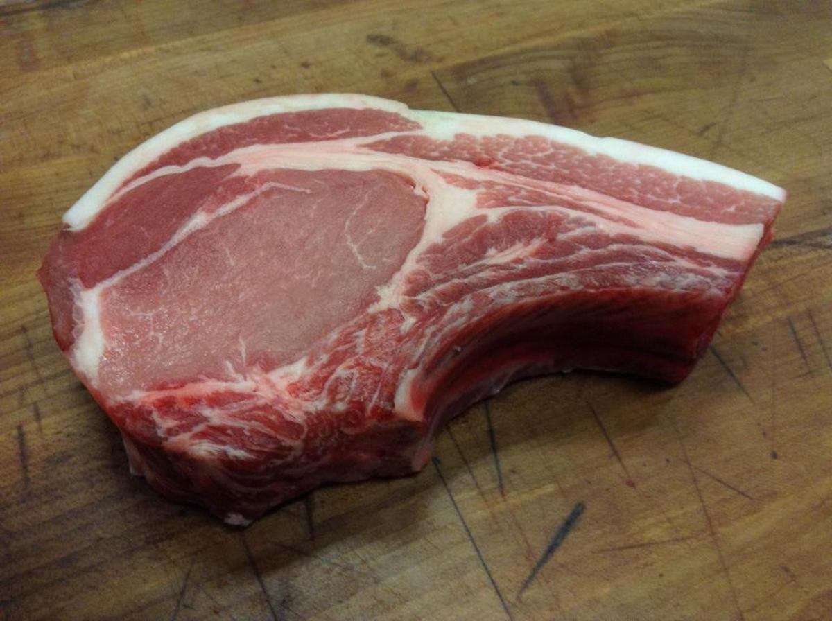 A pork rib chop is succulent and tender on the grill, seasoned simply with only salt and pepper.