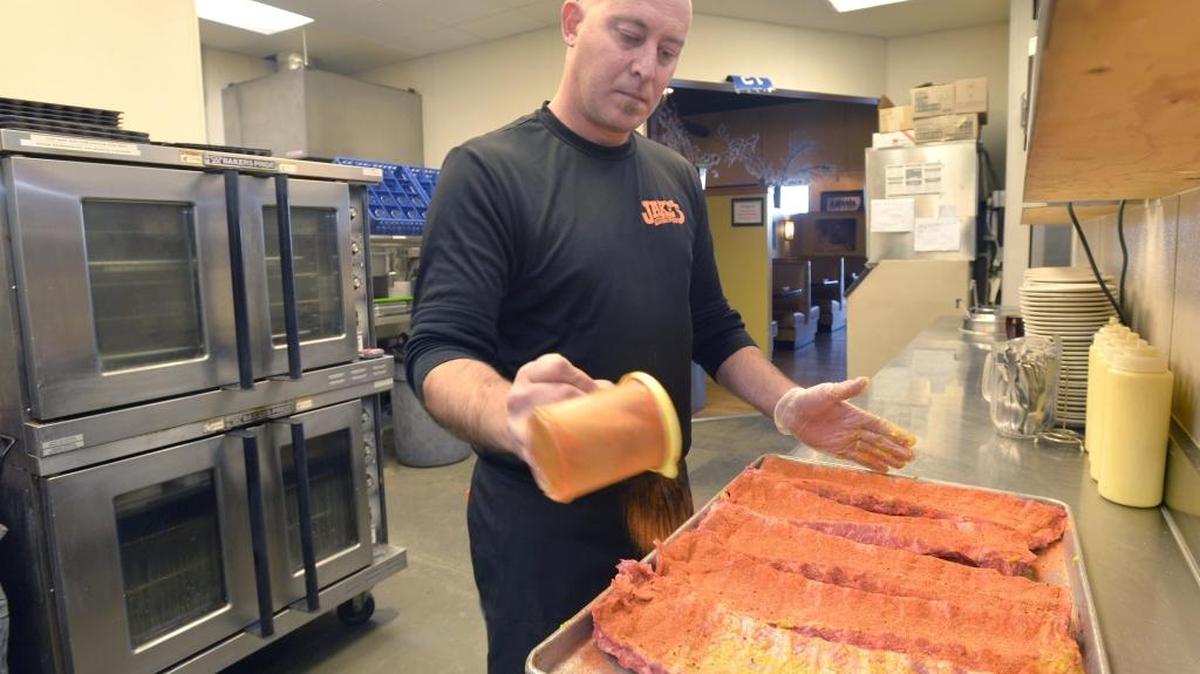 Owner Brian Poag seasons baby back pork ribs at his restaurant, Jake’s Western Grill, in Lynden, Wash., on Nov. 27, 2015. The restaurant is giving a 20 percent discount on meals for first responders, U.S. border agents, active duty U.S. military and veterans.