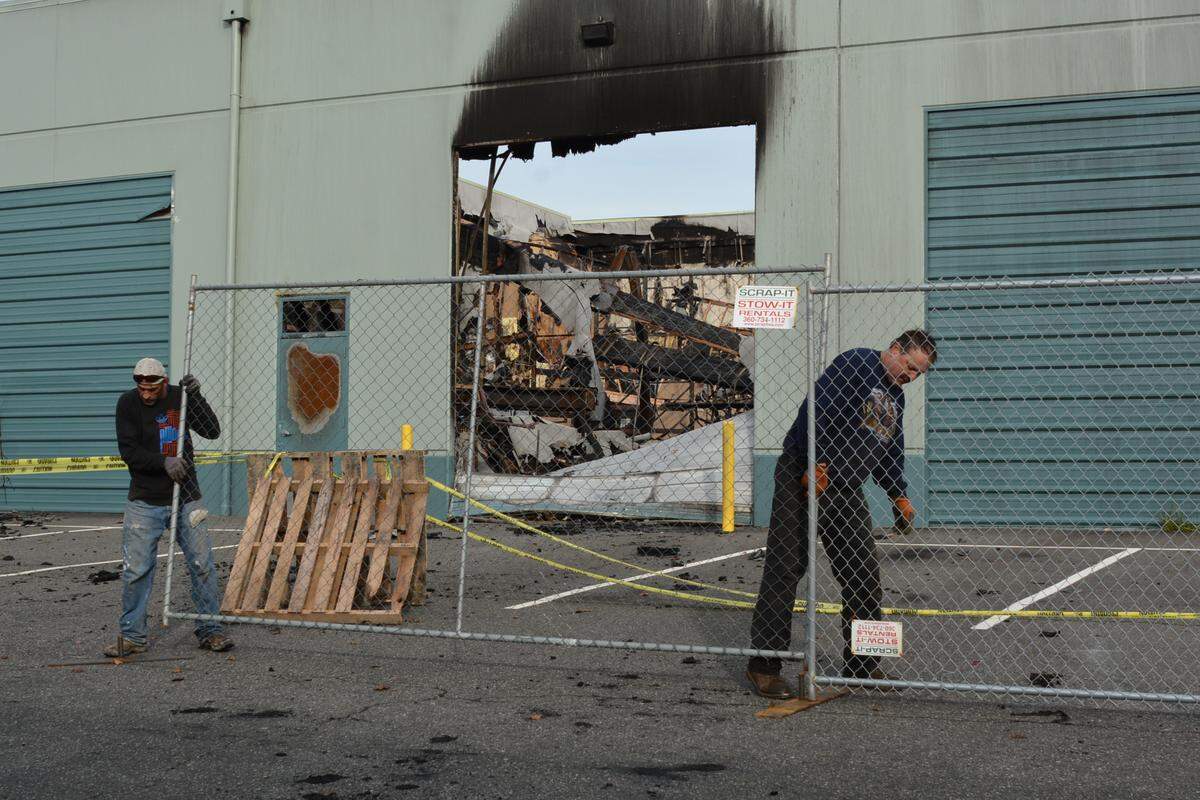 Shawn Robert, left, and Stepan Baydak of Scrap-It install fencing around the damaged Blue Sea Systems building Nov. 12, 2018, in the Cordata area. Craig Stuart Wise, 54, was sentenced Thursday in Whatcom County Superior Court to 2¼ years in prison, with 1½ years probation for first-degree arson for the destruction caused in the Blue Sea Systems fire.