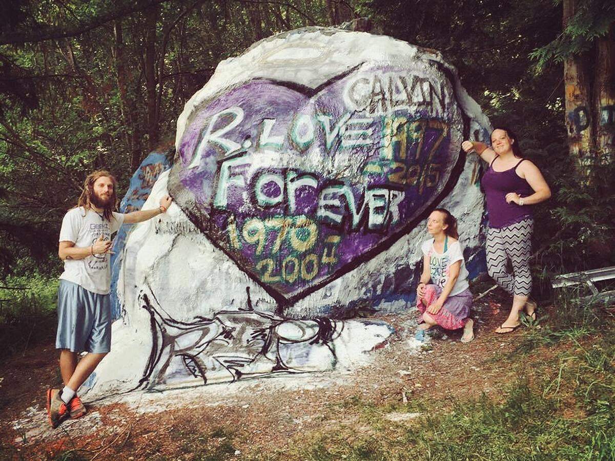 Bellingham residents and siblings Justin Kennedy, left, April Gates and Rebecca Hawk paint “the rock” in 2016 in memory of their late mother and brother.