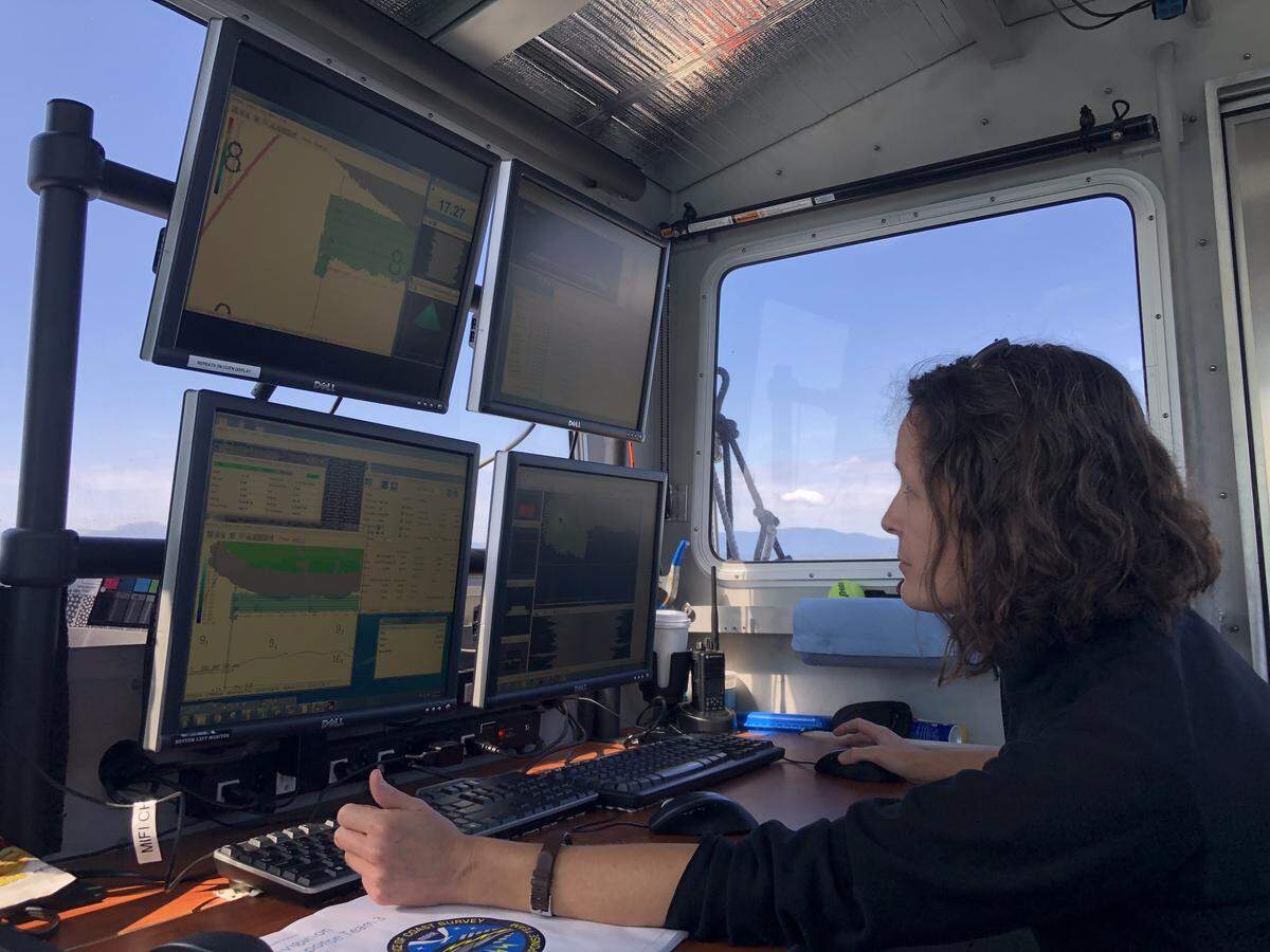 Martha Herzog, a physical scientist with the National Oceanic and Atmospheric Administration, monitors progress on board NOAA’s NRT-34 surveying boat in Bellingham Bay in June. Herzog, who’s based out of NOAA’s headquarters in Silver Spring, Maryland, traveled across the country to act as the third crew member for the survey.