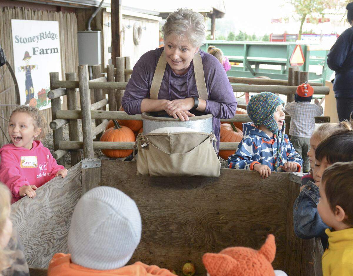 Stoney Ridge Farm co-owner Debi Gavette shows a group of school kids how apples are harvested during a fall festival in Everson in 2015.   The farm will re-open next month after a two-year hiatius.