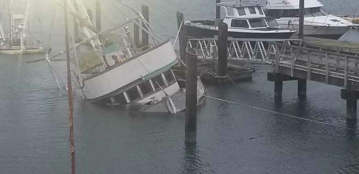 The F/V Furious Sea takes on water while tied to a dock in the channel at Sandy Point on Thursday. Behind the Furious Sea are the remains of the F/V Coral Sea, which sank in 2016.