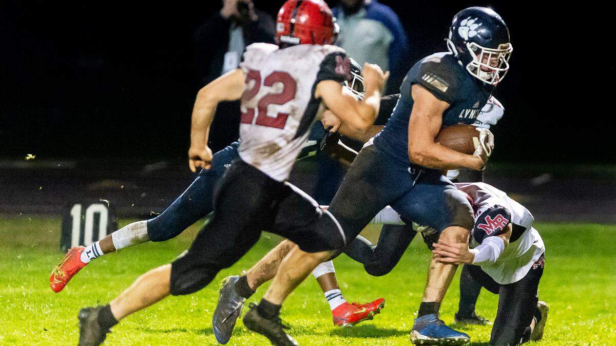 Mount Baker linebacker Jesse Sande (22), left, moves in as teammate Landon Smith (2), on ground, attempts to stop Lynden Christian tight end Kade Eldridge (44) as he runs 21 yards for a touchdown during the third quarter in their Division 1A conference game on Friday evening, Oct. 22, at Lynden Christian High School. Eldridge’s touchdown, and blocked extra point, resulted in a 6 to 0 lead as Lynden Christian went on to defeat Mount Baker 12 to 0.