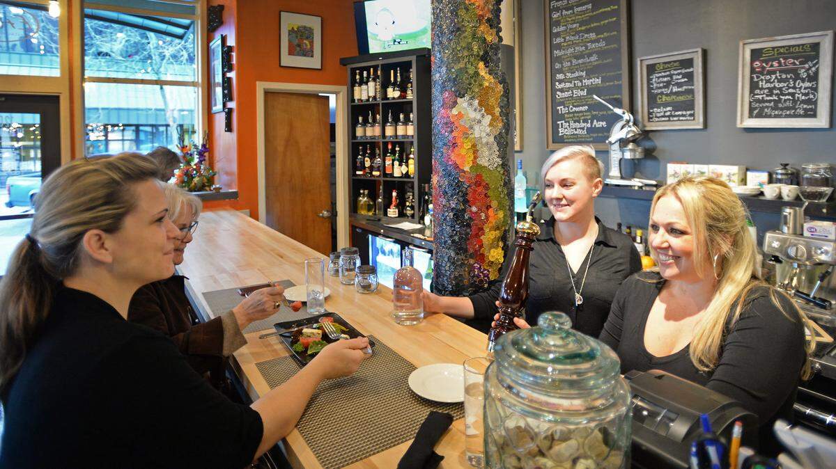 Customers Khara Turner, left and Alana Hansen are served by Lydia Davis and Brie Mueller at the  Eat Restaurant and Bar in downtown Bellingham on Feb. 5, 2016.