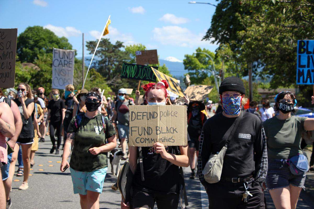 Around 200 people march Saturday, July 25, in Bellingham in a protest against the presence of federal law enforcement officers in Portland, Oregon, in solidarity with the Black Lives Matter movement and in support of defunding police.