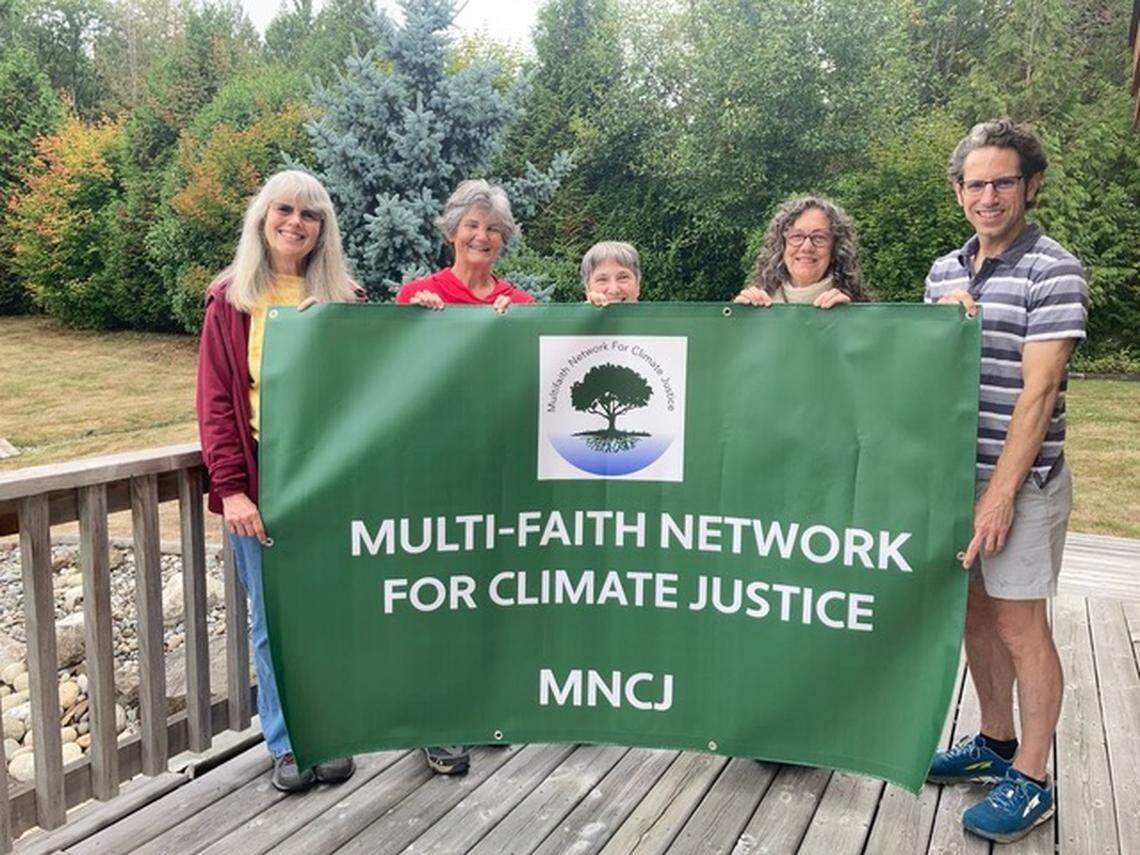 Diane Sue, Betsy Gross, Judy Hopkinson, Jillian Froebe and Brian Johnson hold the Multifaith Network for Climate Justice banner in 2021 in Bellingham.