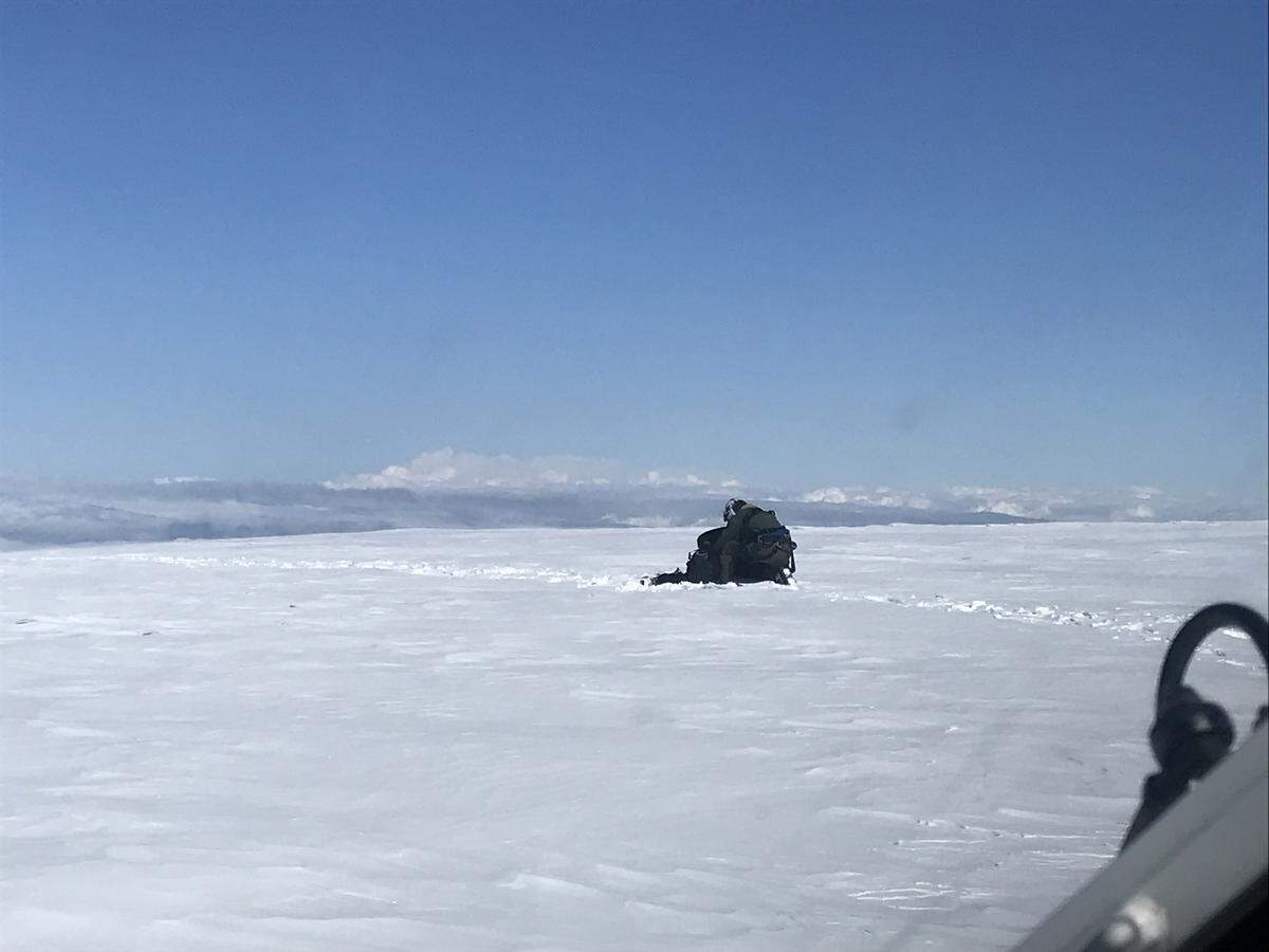 A member of the U.S. Navy's search and rescue helicopter crew assists one of the missing climbers Monday morning at the summit of Mount Baker.