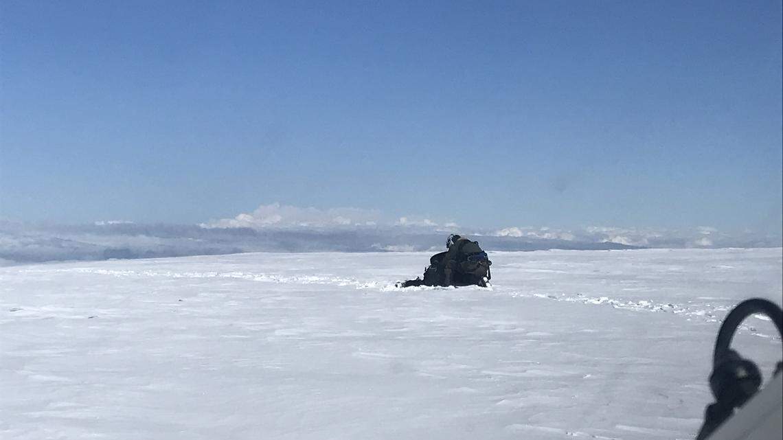 A member of the U.S. Navy's search and rescue helicopter crew assists one of the missing climbers Monday morning at the summit of Mount Baker.
