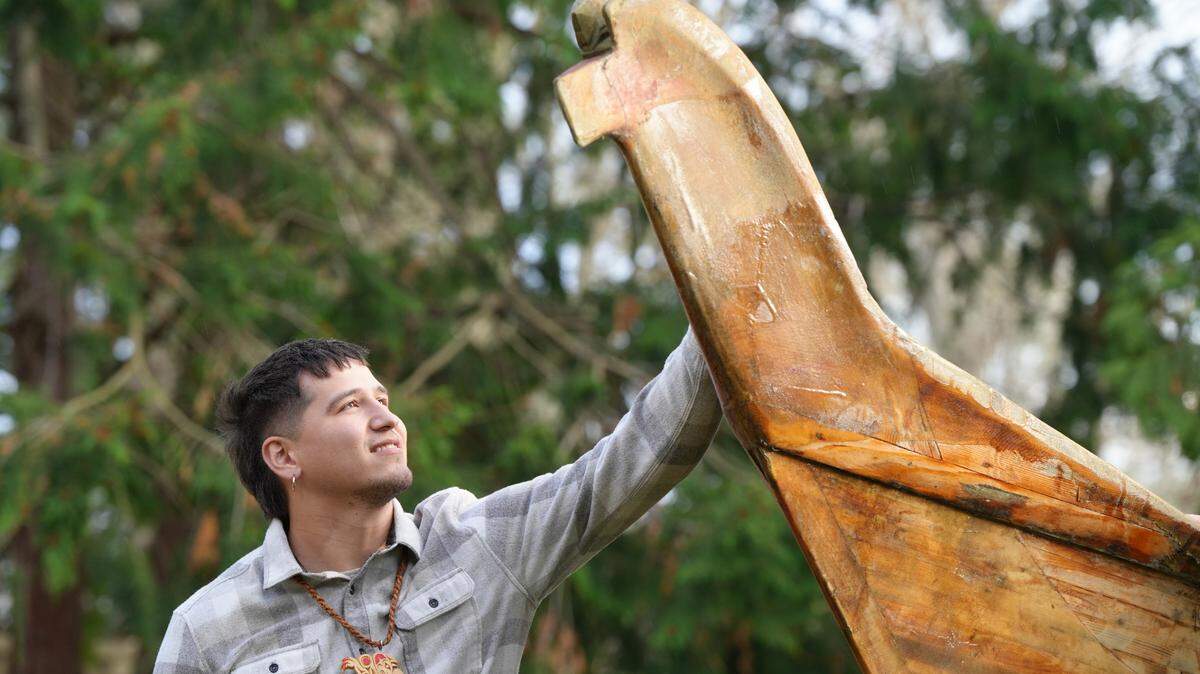 Free Borsey stands at the head of a canoe he plans to refurbish with his brother as part of an effort to revitalize the Lummi Youth Canoe Family on the Lummi Reservation.