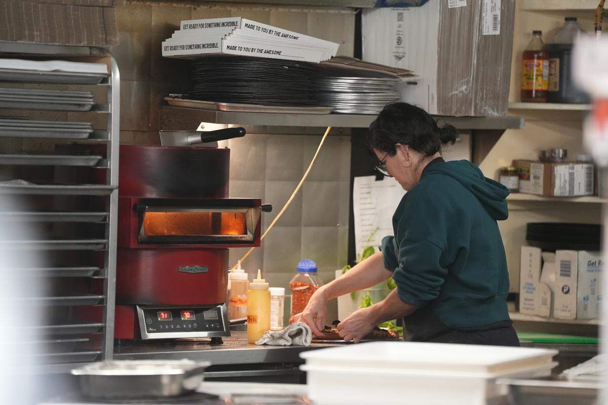 An employee makes a pizza at Rome Bakery and Market on November 11, 2025, in Bellingham, Wash.