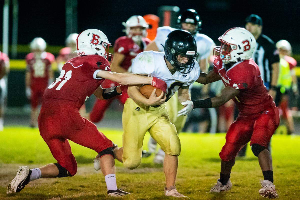 Bellingham defenders Josh Twedt (31), left, and Alex Breeding (4), right, attempt to stop Meridian running back Josh Elmer (30) during a long run stopped shy of a touchdown during the second quarter on Friday evening Sept. 24, at Meridian High School. Meridian went on to score a touchdown to defeat Bellingham 26 to 14.
