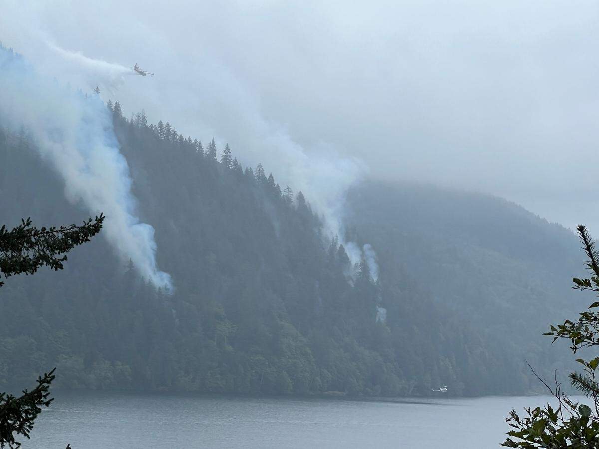 A tanker aircraft drops water on the Blue Canyon Fire as seen from the High Bridge on Tuesday across Lake Whatcom.