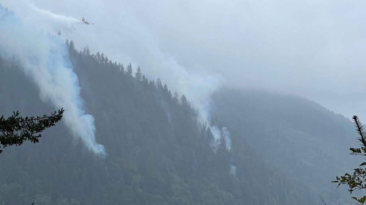 A tanker aircraft drops water on the Blue Canyon Fire as seen from the High Bridge on Tuesday across Lake Whatcom.