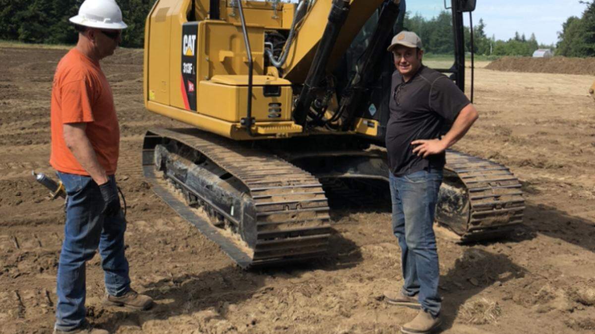 Todd Vaset, director of coaching, speaks with Brent McGuire, a club member and machinery operator. Vasey led the field regrading team at Chuckanut Bay Rugby’s facility in Ferndale in the spring of 2020.