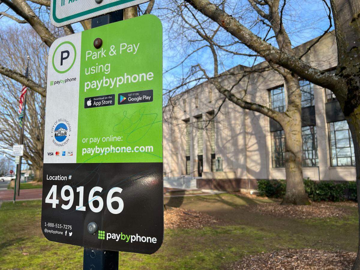 A sign outside City Hall at 210 Lottie St. in Bellingham tells drivers to use the PayByPhone mobile app or use its website for parking. Scam stickers found on some parking meters were telling drivers to scan a bogus QR code.