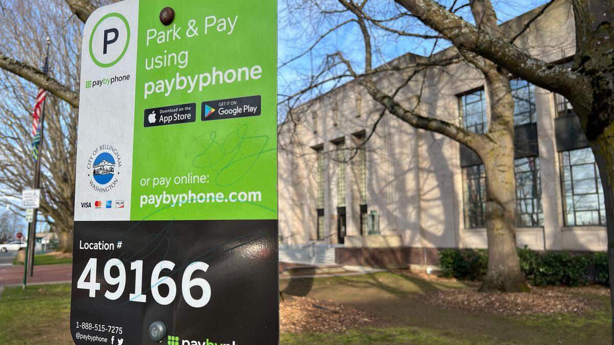 A sign outside City Hall at 210 Lottie St. in Bellingham tells drivers to use the PayByPhone mobile app or use its website for parking. 