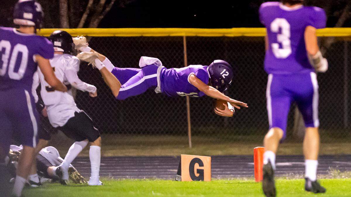 Nooksack Valley quarterback Joseph Brown (12) dives for a touchdown early in the second quarter after a long run from midfield on Friday evening Sept. 30, at Nooksack Valley High School in Everson. The touchdown and extra point gave Nooksack a 28 to 0 lead as they went on to beat Meridian 48 to 15.