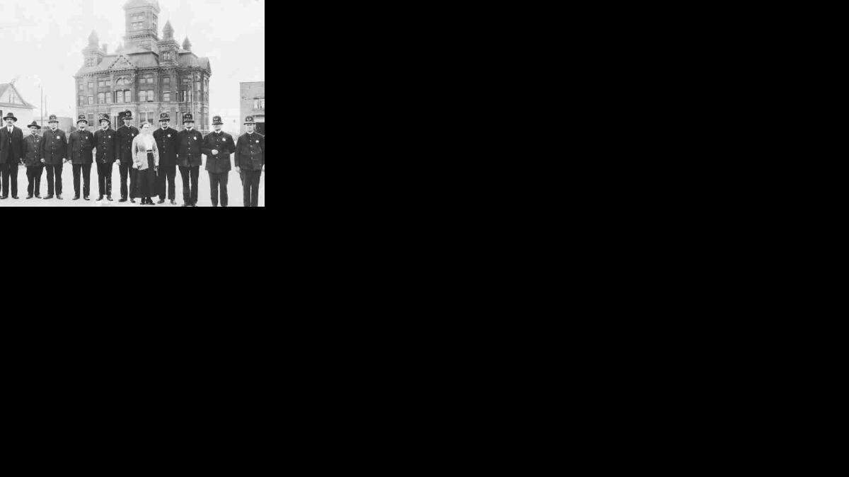 Members of Bellingham's police department" poses in April 1919 in front of City Hall, now the Whatcom Museum of History & Art. At that time, the police department and city jail were located in the basement of City Hall.