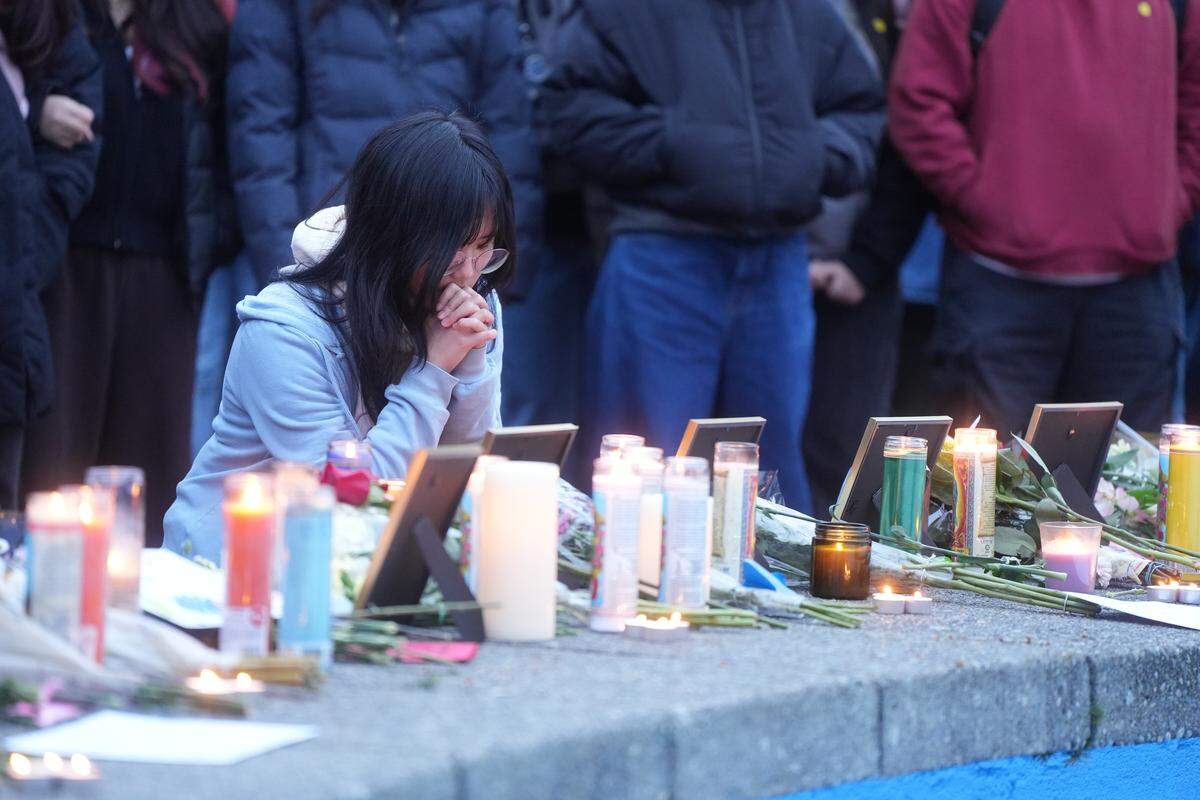 During an anti-ICE vigil at Western Washington University on Monday, a woman mourns in front of a framed image of Renee Good, a Minneapolis resident and American citizen who was killed by an ICE agent earlier this month.
