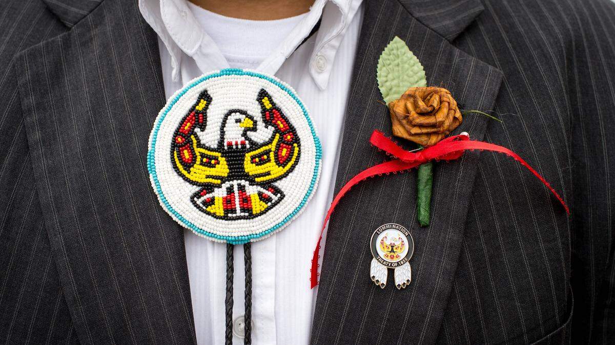 A tribal member wears a Lummi emblem on his bolo tie and a cedar rose on his lapel during a rally during the White House Tribal Nations Conference to urge Congress to uphold treaty rights and reject permits for a shipping terminal in Lummi’s fishing waters at Freedom Plaza in Washington D.C., Nov 5, 2015.