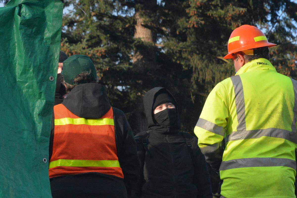 City parks workers face off with protesters angered that the city won’t allow homeless people to camp at Laurel Park in Bellingham Friday, March 19.