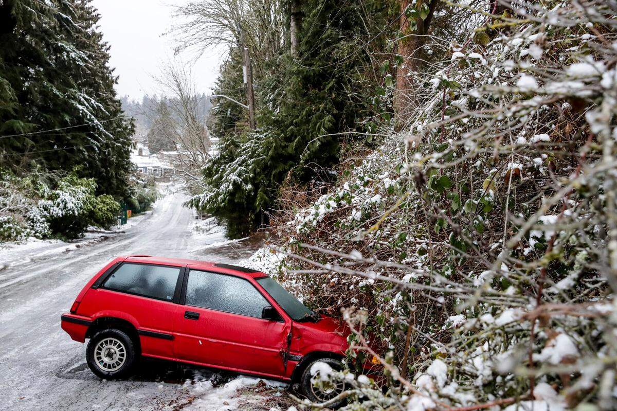 A car is left on the side of the road due to dangerous road conditions Friday, Dec. 23 in Seattle. Winter weather is blanketing the U.S. as a massive storm sent temperatures crashing and created whiteout conditions.