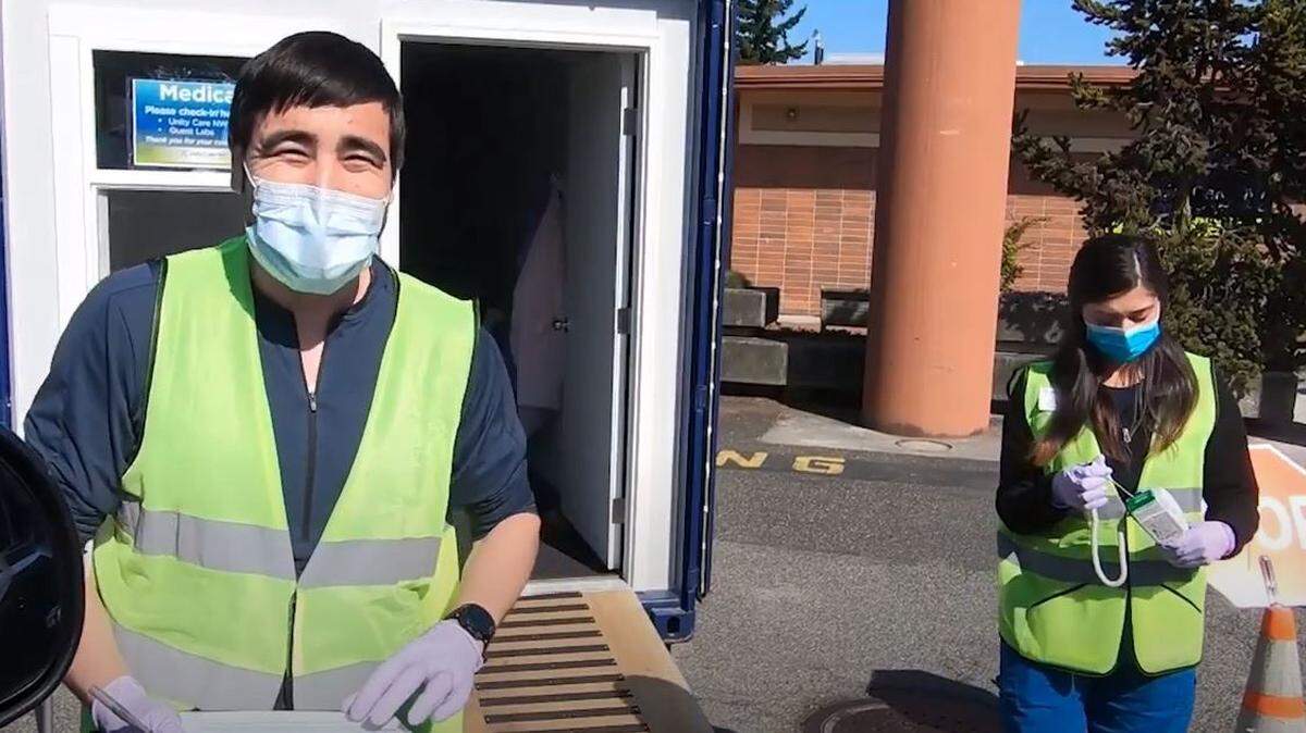 Dental assistants Jesse Arnott, left, and Eva Larios check in patients for curbside pharmacy pickup, instituted to meet COVID-19 social distancing precautions at Unity Care NW in Bellingham.