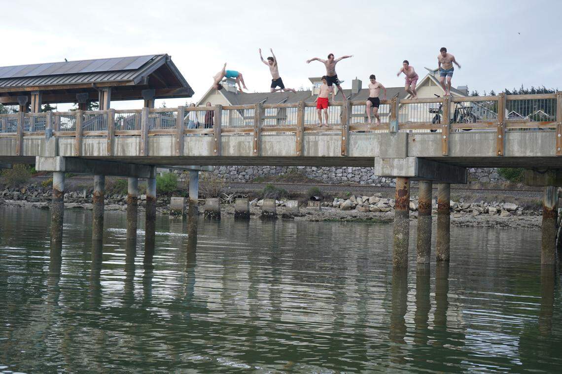 A group of Western Washington University students jump off Taylor Dock on Wednesday, April 29, in Bellingham, Wash. The students are part of the university’s Cold Plunge Club, which encourages cold water exposure.