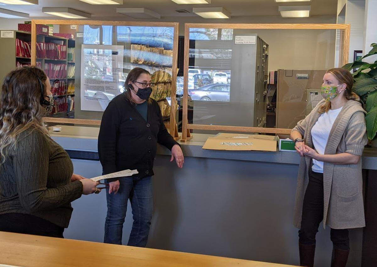 Whatcom County Health Department Director Erika Lautenbach, right, speaks with clerks at the department.