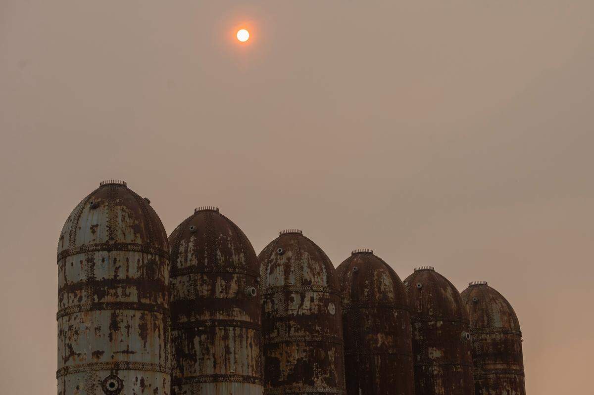 The sun, over the former digester tanks on the Bellingham waterfront, appears orange due to smoke from wildfires that blew into Whatcom County in August 2021.