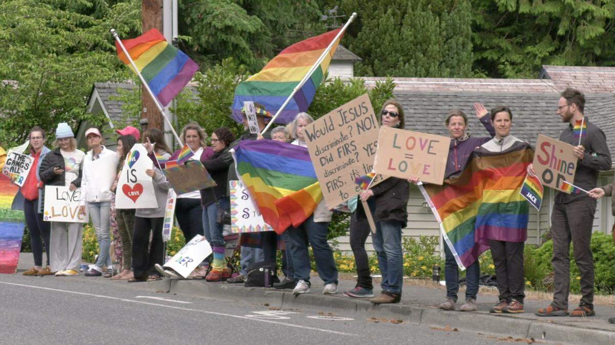 About 100 protesters gather early Monday outside The Firs east of Bellingham to protest the firing of 18-year-old Jace Taylor. Tom Beaumont, executive director of The Firs, told The Herald that Taylor was fired for being gay.