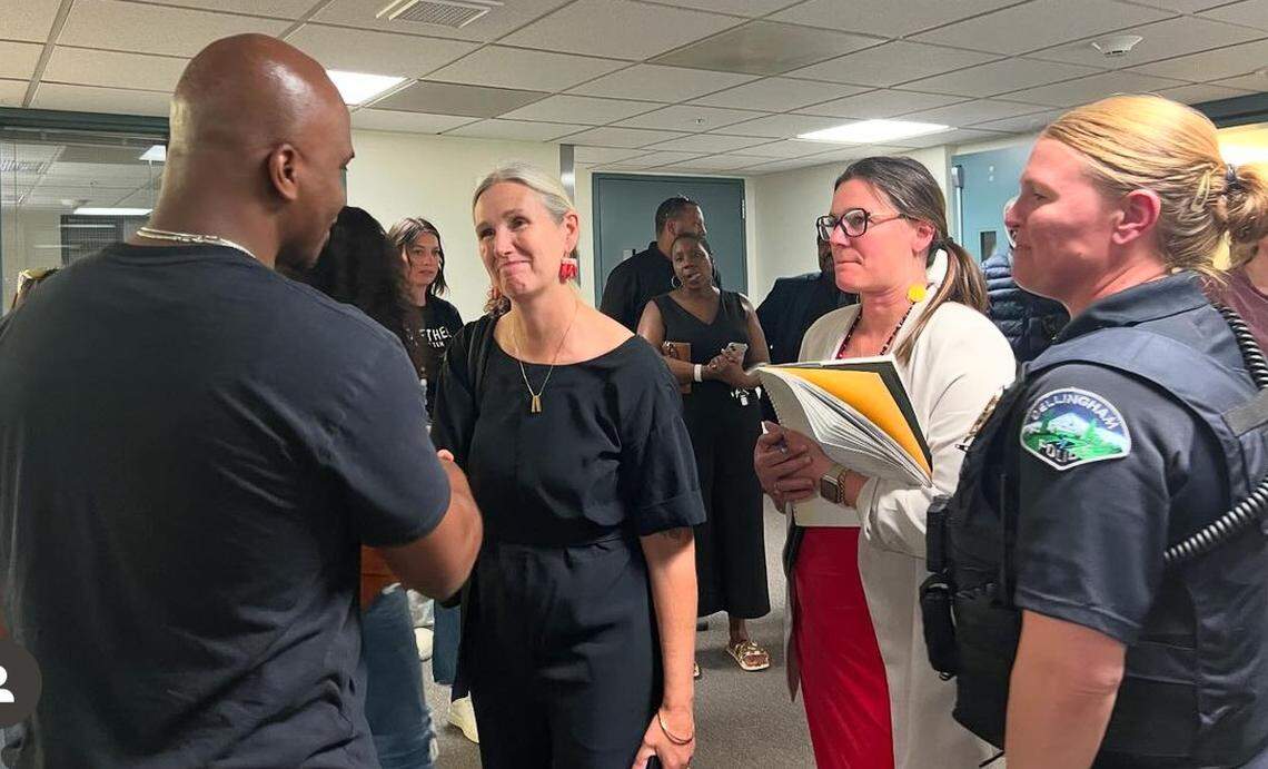 Bellingham Mayor Kim Lund, center, greets DeVante Blow, left, at the Whatcom County Courthouse after a bail hearing in the the case of a hate crime attack against Blow’s son. At right is Police Chief Rebecca Mertzig.