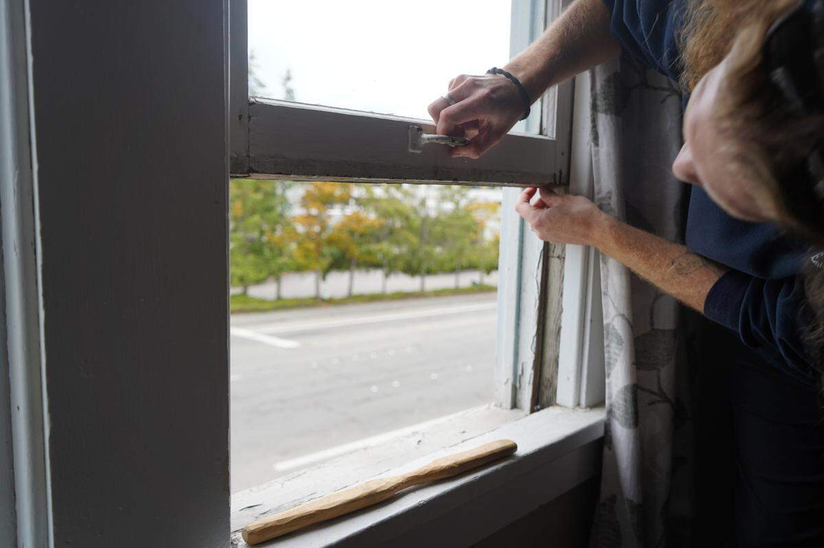 Aidan Hersh opens an upstairs window in his house at 1210 Ellis Street on Sept. 27, 2023, in Bellingham, Wash. Many of the windows in the house were not insulated, frequently collected condensation and contributed to mold growth on the wood around them. The tenants wanted them replaced.
