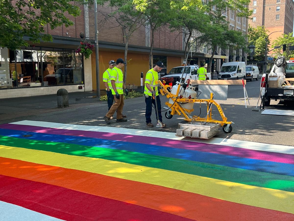A crew from the Bellingham Department of Public Works puts the finishing touches on a rainbow-colored Pride crosswalk on Cornwall Avenue between Holly and Magnolia streets in downtown Bellingham on Thursday.