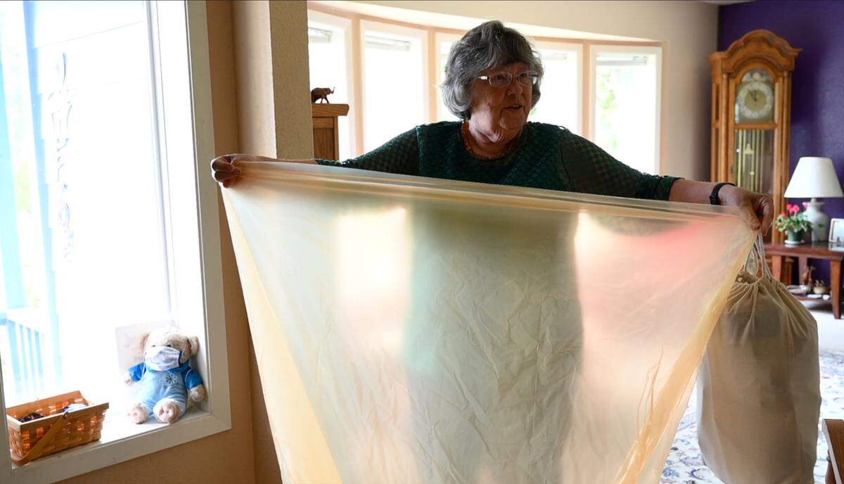 Ronalee Kincaid holds up a bag on Thursday, June 10, that can be filled with garments and textiles that Ridwell will pick up from her Bellingham home for recycling and reuse.